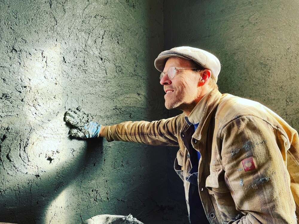 En man lerklinar en vägg.