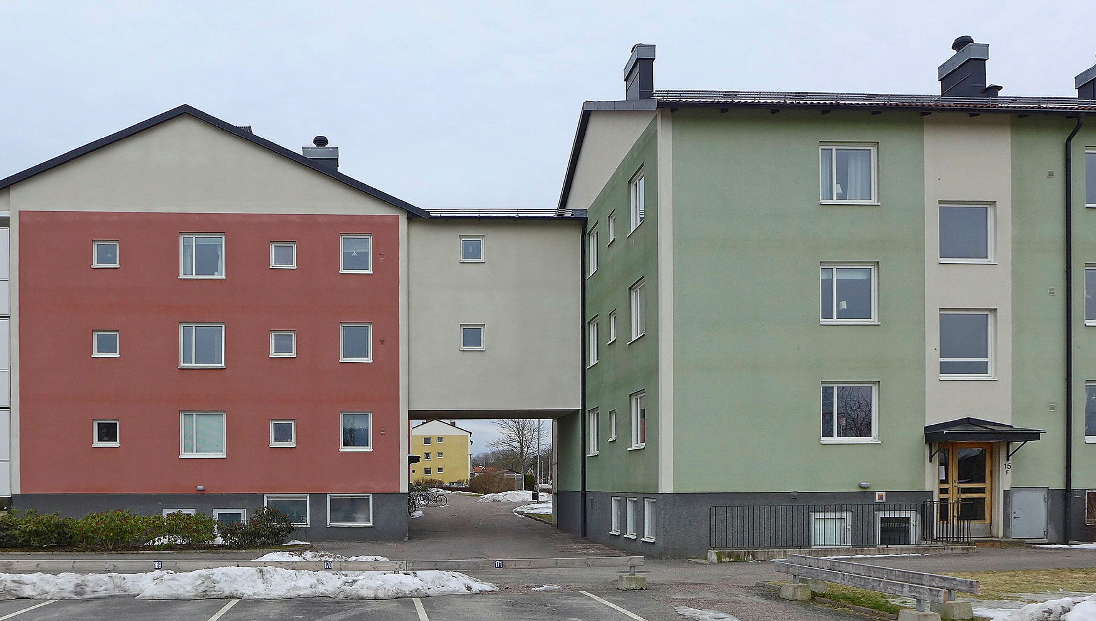 Putsat flerfamiljshus i röda och gröna toner