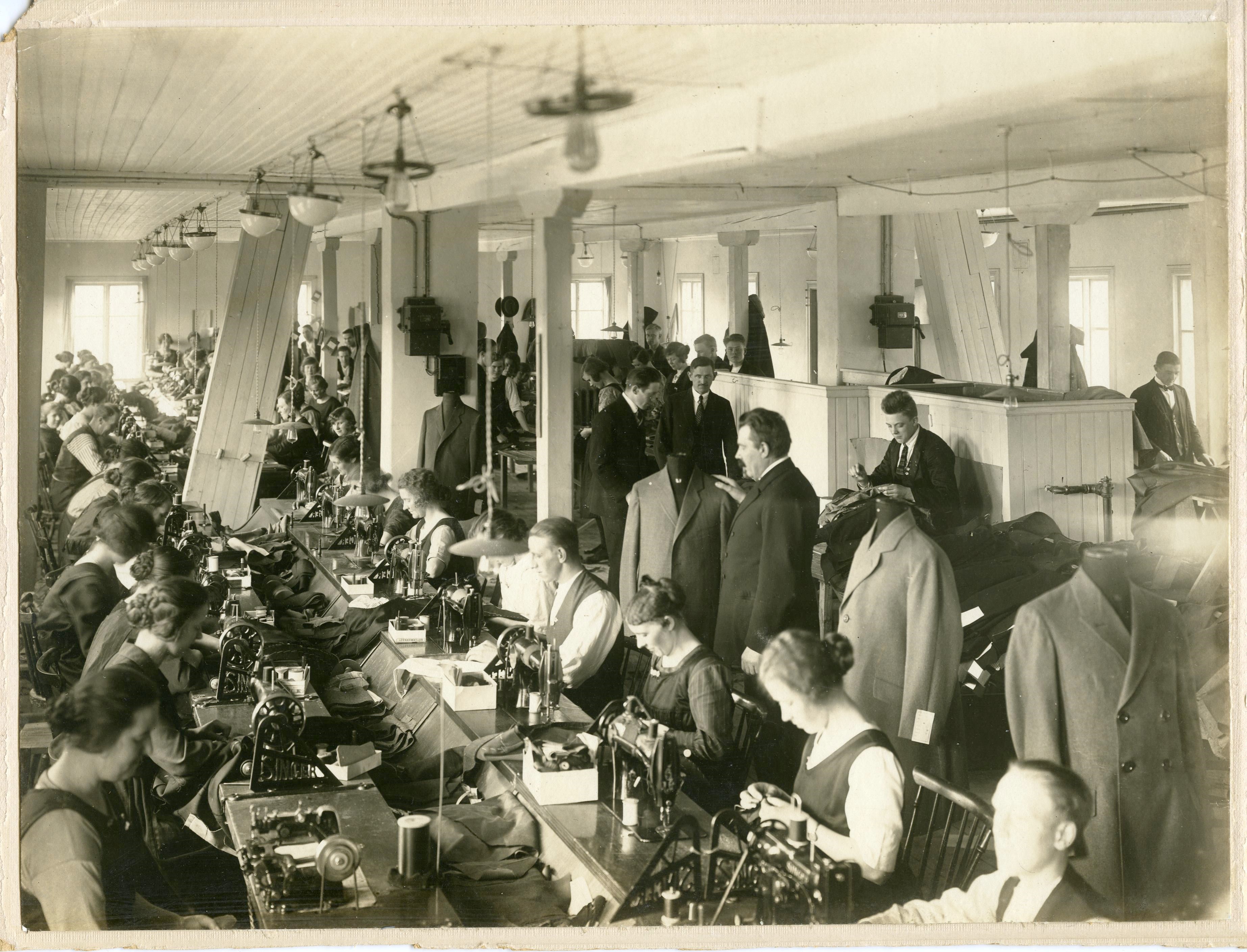 Kvinnor sitter i en industrilokal och syr - äldre foto från ca 1920-tal.