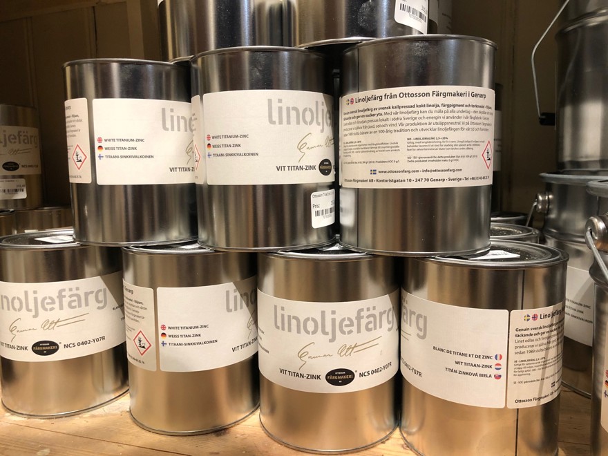 färgburkar i plåt staplade i hylla