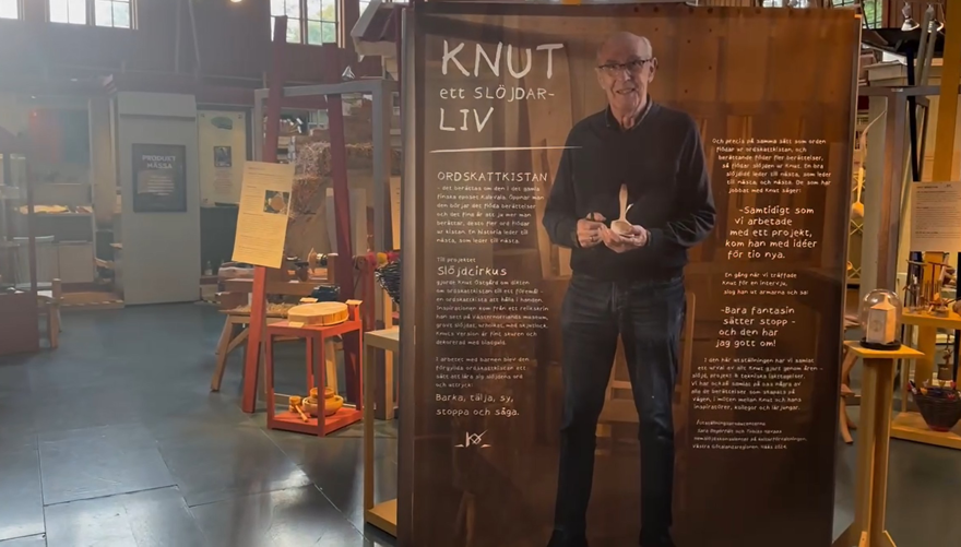 Utsällningshall med träföremål och en vepa med en man och texten KNUT ett slöjdarliv