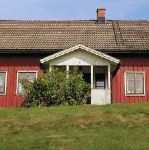 Ett rött hus med vitmålad öppen förstukvist
