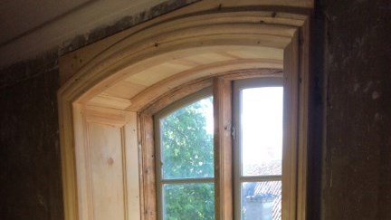 En fönsternisch i ett gammalt hus. Flera delar av nischen är lagade med nytt virke. 