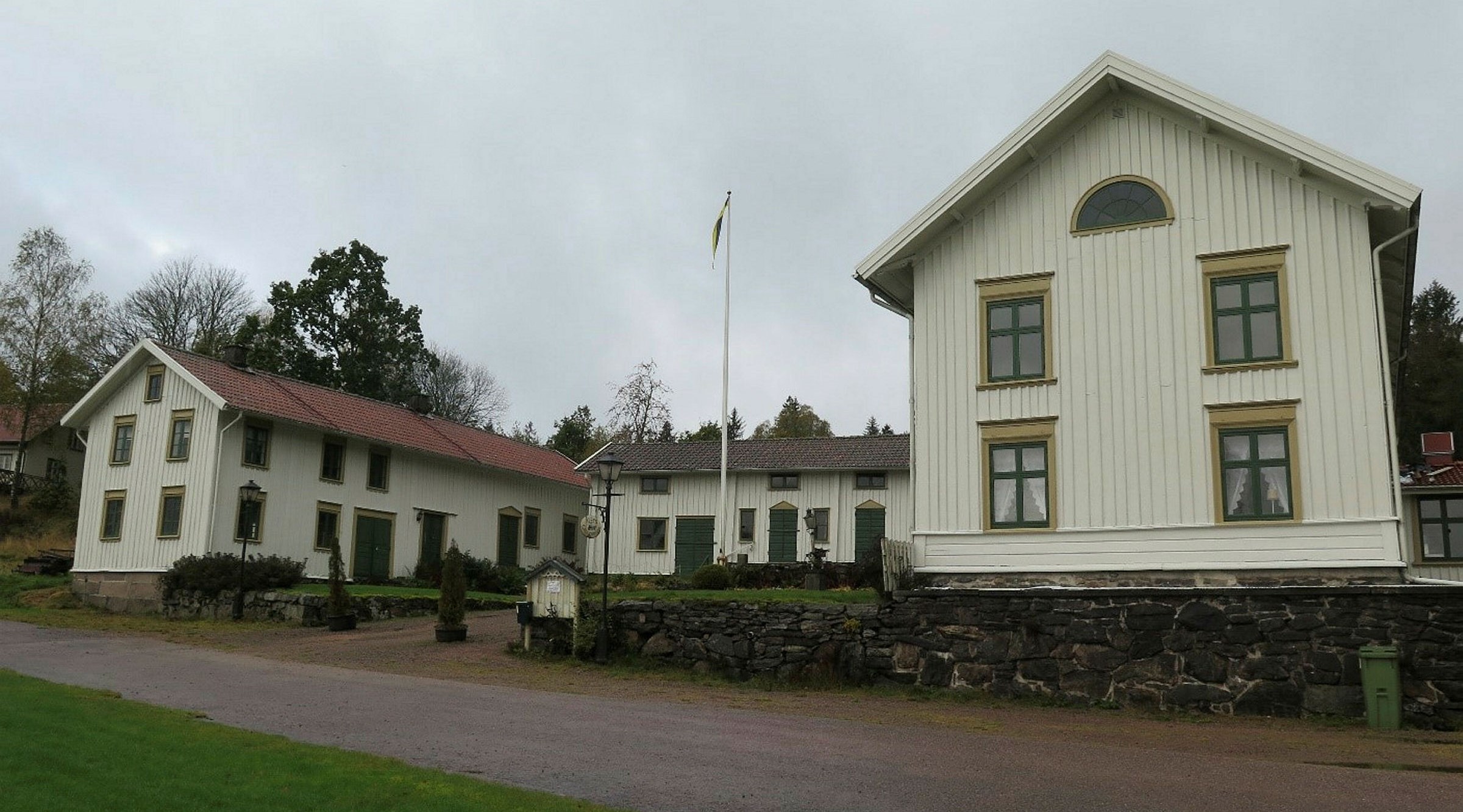 Ett stort ljust trähus med två flyglar