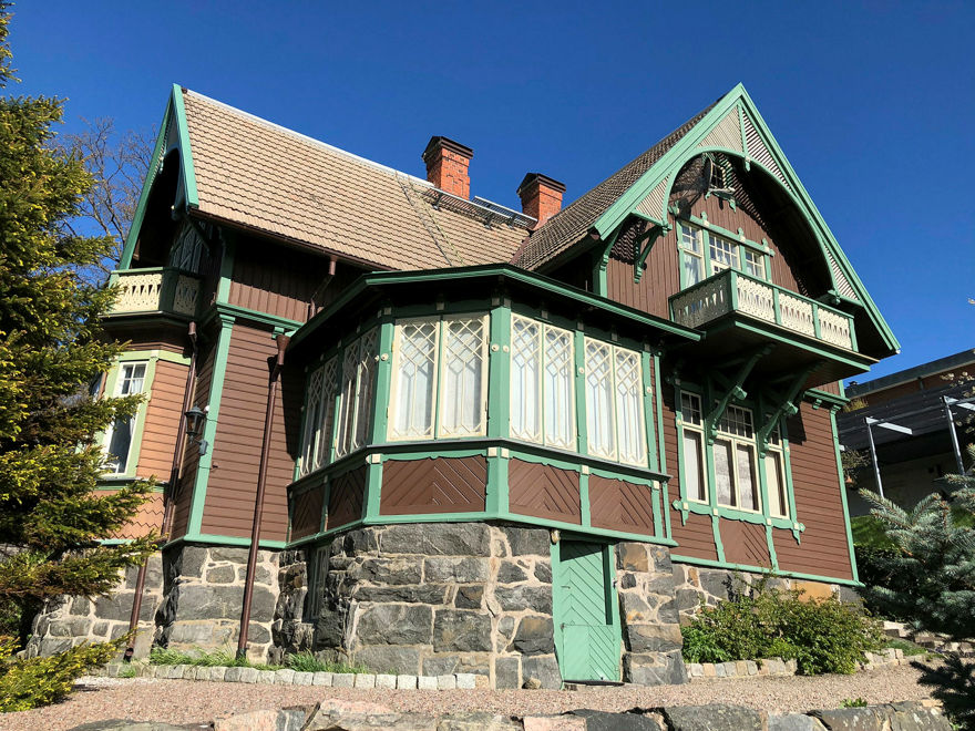 ett stort brunt trähus med snickarglädje