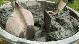 En hink med lera och en spade och en murslev