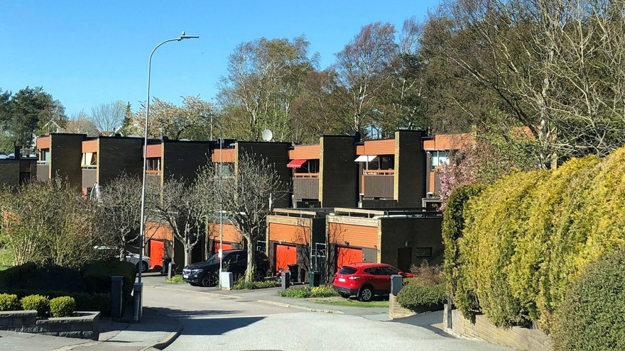 Radhus i ljust tegel, orange och bruna trädetaljer.