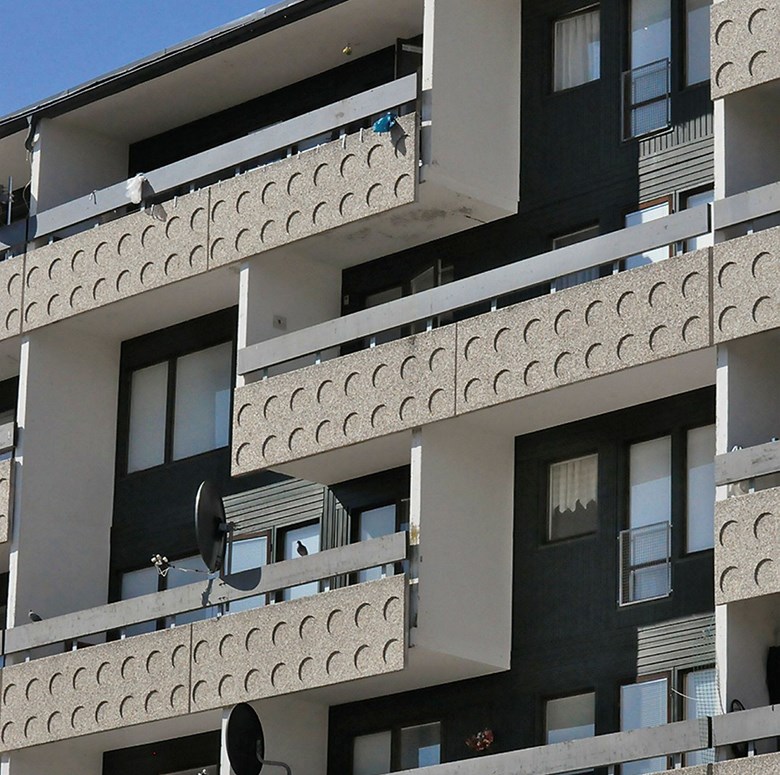 Ett flerfamiljshus med mönstrade balkongfronter och mörk panel innanför.