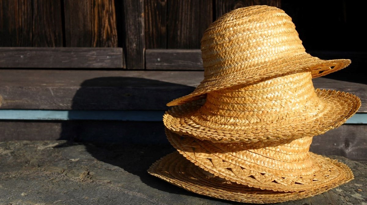 Fyra hattar staplade på varandra. Hattarna är gjord i flätad halm.