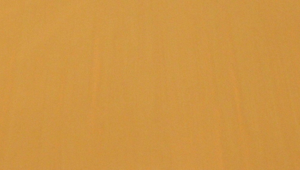 En gulmålad yta med viss flammighet