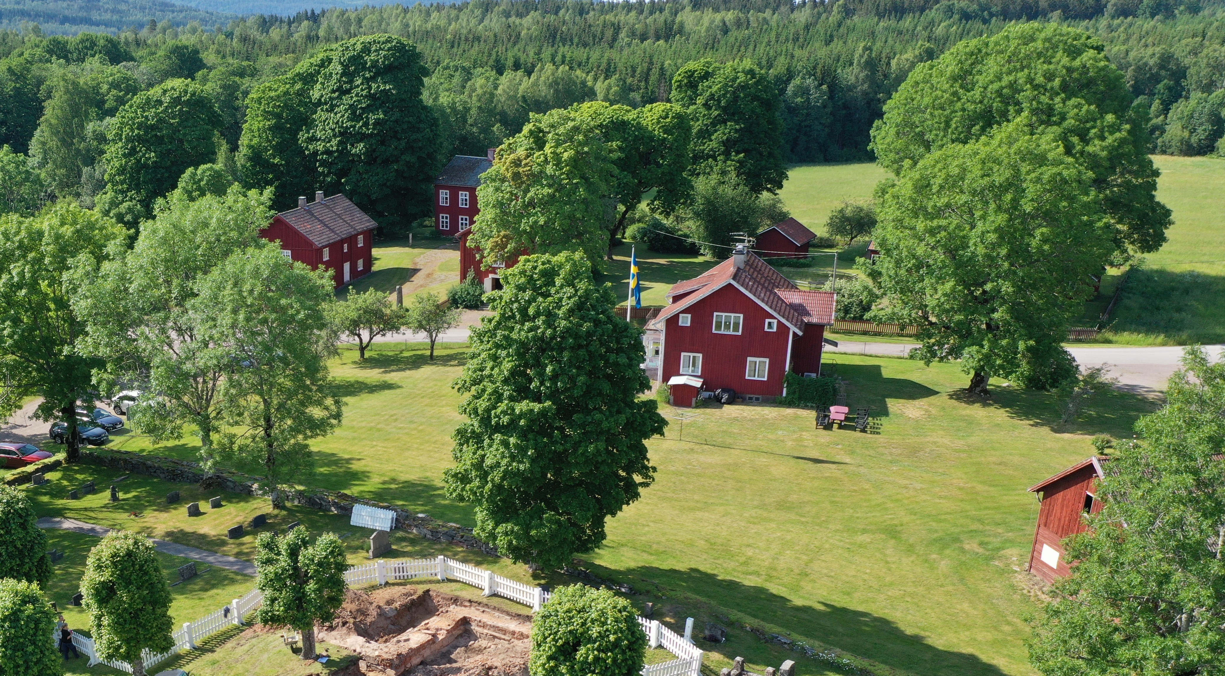 I en grönskande omgivning ligger flera röda byggnader