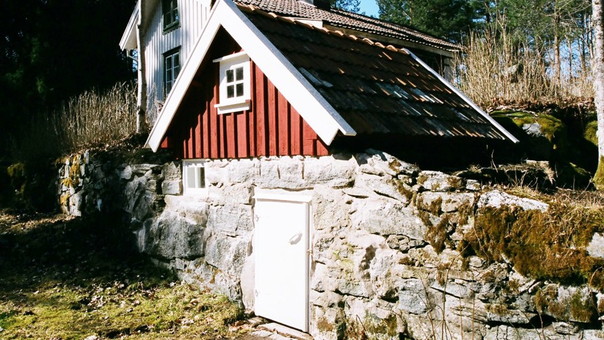 Jordkällare med grund av natursten. Målad i rött och vitt.