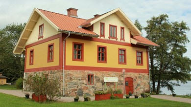 Putsat gult och rött hus med hög stensockel