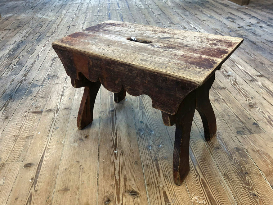 Fint sliten liten pall på slitet trägolv