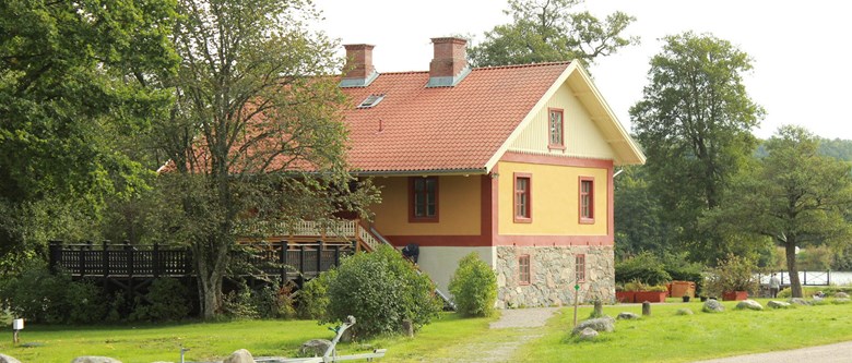 Putsat gult hus med rött tegeltak
