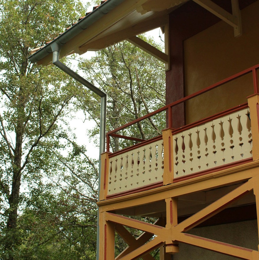 Balkong i trä med gula och röda kulörer