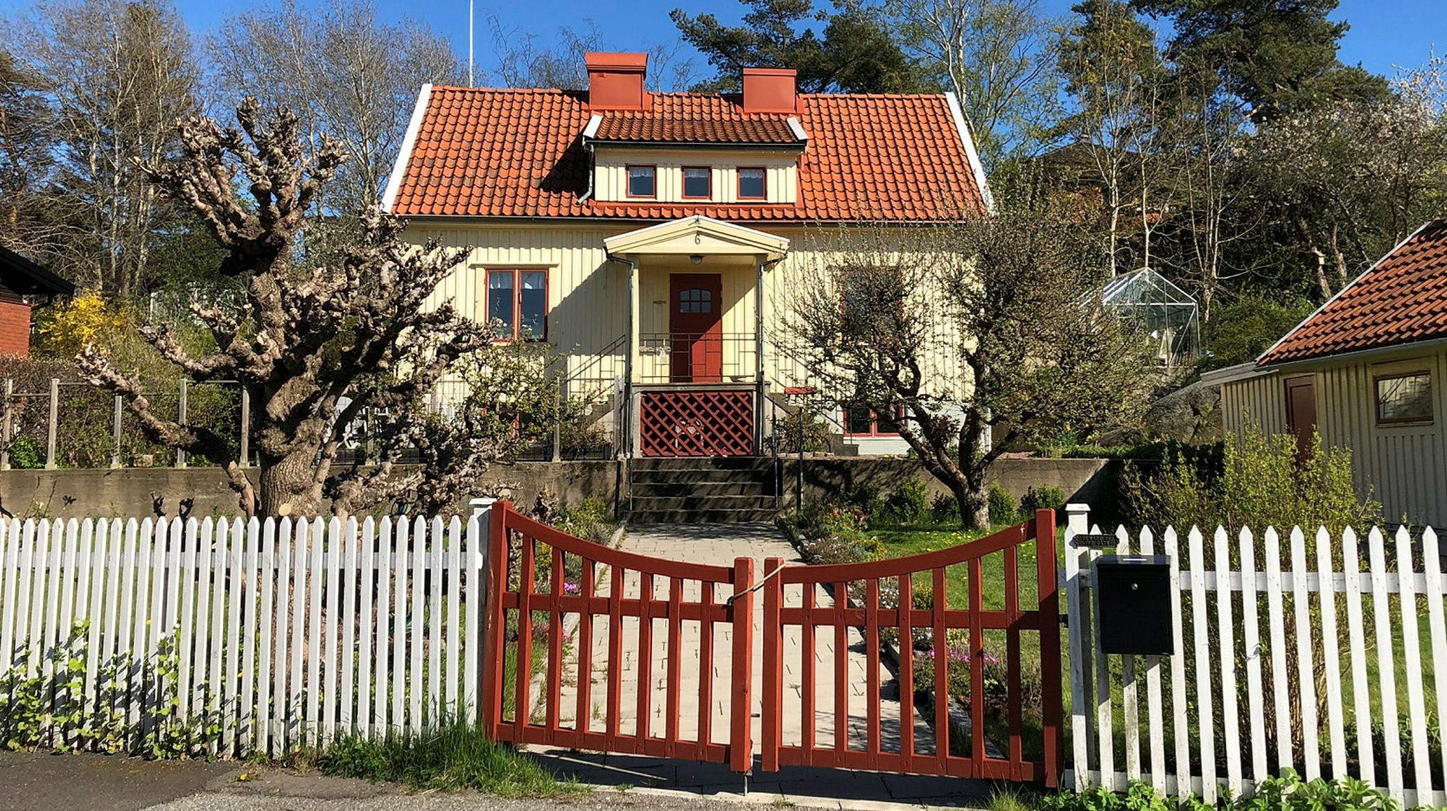 En liten gul villa med röda detaljer.