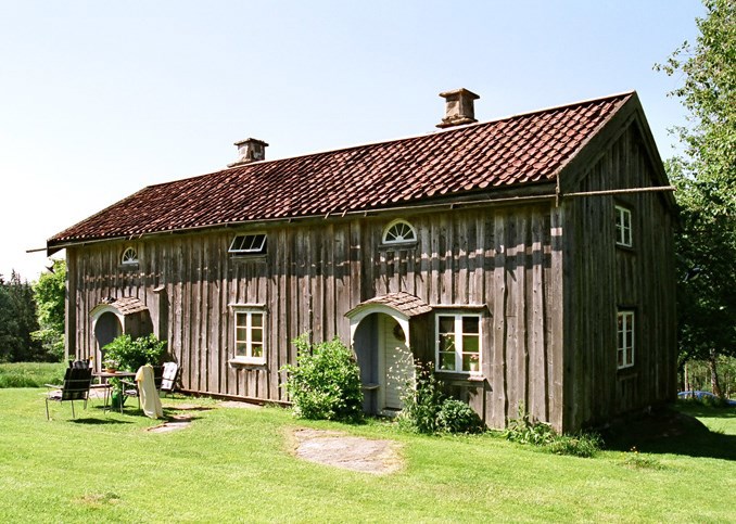 Ett tvåvånings parhus med grå träpanel och små rundade entréer