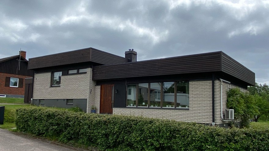 Vit tegelvilla med svarta detaljer.