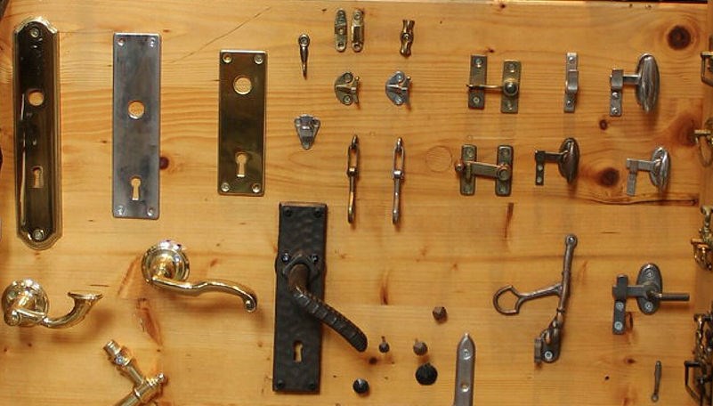 Olika dörr- och fönsterbeslag uppsatta på vägg