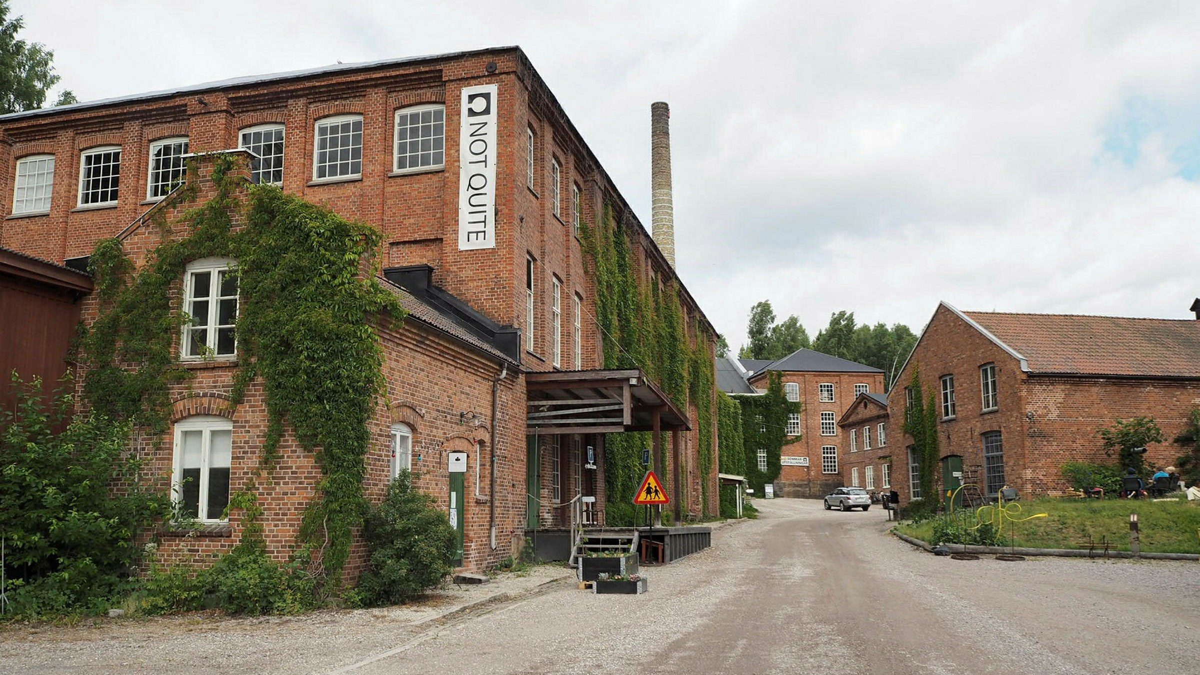 Miljöbild över bruket Fengersfors med sina röda tegelbyggnader.