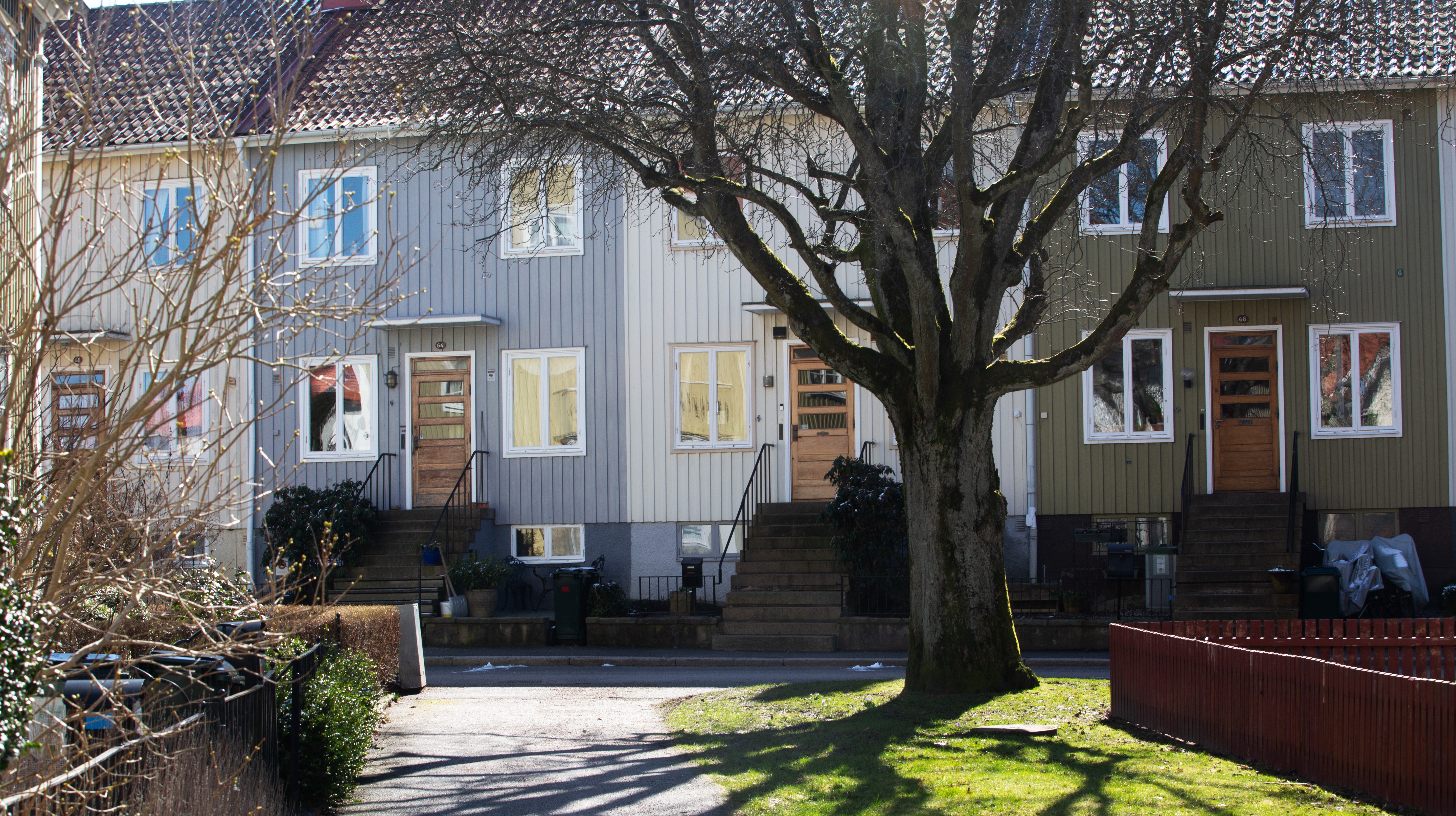 Tvåvånings radhus där alla husen har olika kulörer.