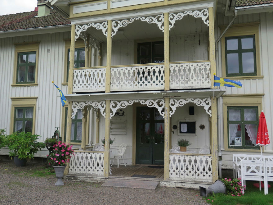 Entré till ett stort trähus med veranda i två våningar